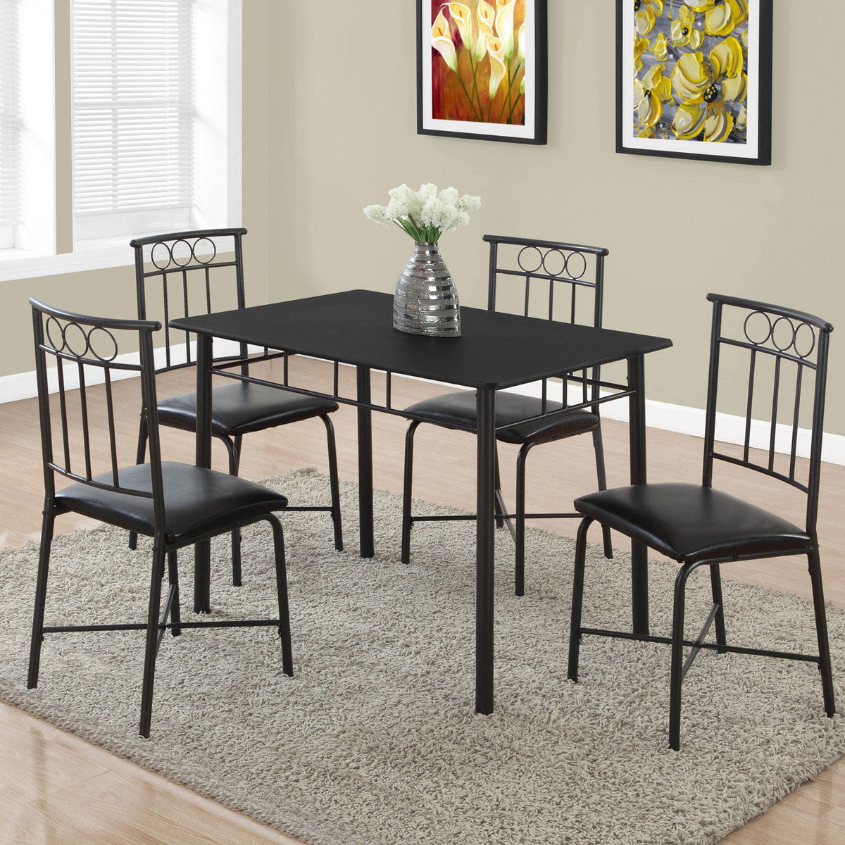 Rectangular dining table set with four black chairs on gray rug, marble-look top