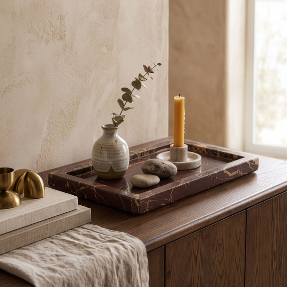 Marble tray with pillar candle and small stones, shown on tabletop styling