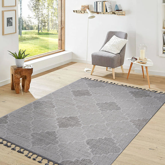 Trellis pattern gray area rug laid flat with dark outline and tassel fringe