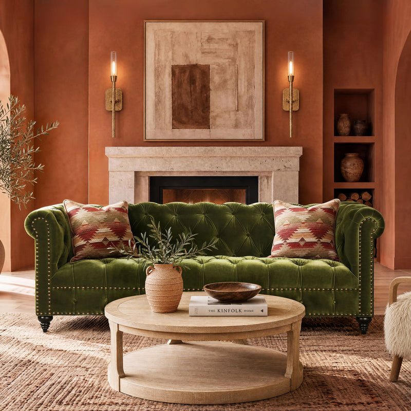 Dark green tufted chesterfield sofa with rolled arms and decorative nailhead trim