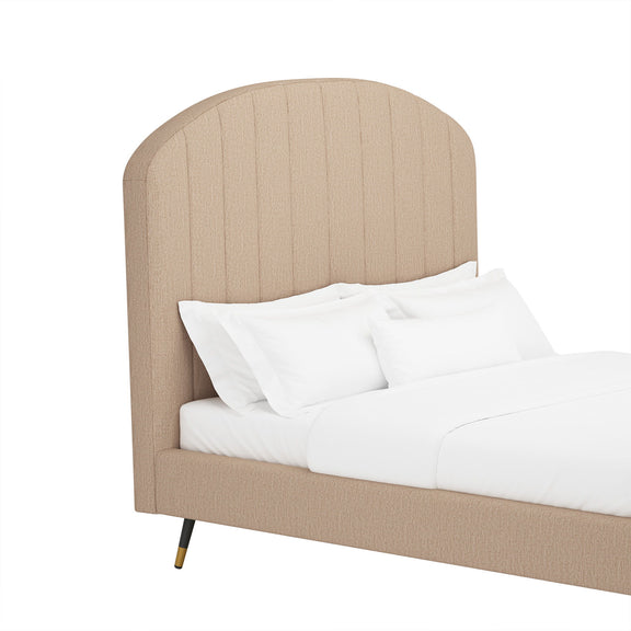 Light brown arched upholstered platform bed with white pillows and duvet
