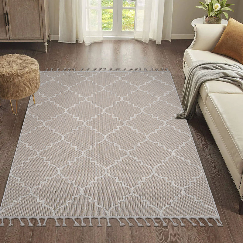 Beige trellis area rug with white geometric lattice pattern and tassel fringe.