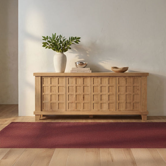 Natural oak sideboard with four paneled doors, flat top, and block legs