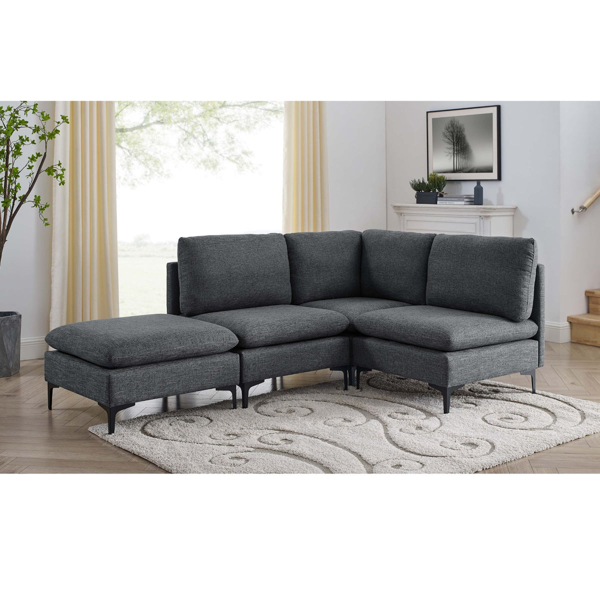 Dark gray modular sectional sofa with chaise and ottoman seats, tall legs