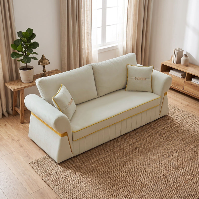 Cream three-seat sofa with gold trim and two accent pillows