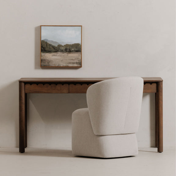 Vintage-brown desk with scalloped apron, topped surface, and light gray chair