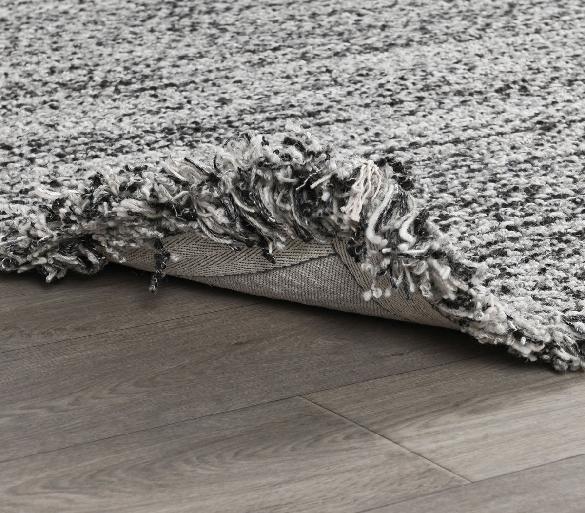 Wool rug with gray shag pile, flatweave backing, and low-profile edge