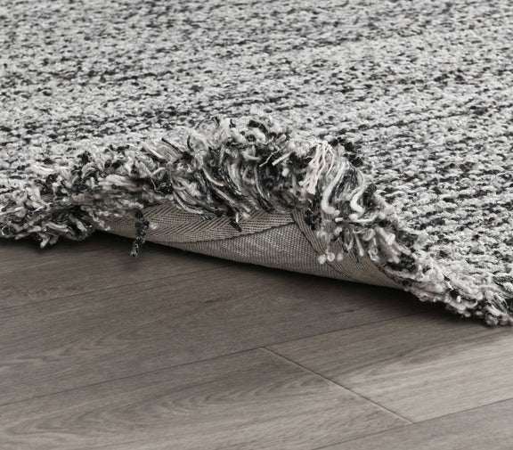 Wool rug with gray shag pile, flatweave backing, and low-profile edge
