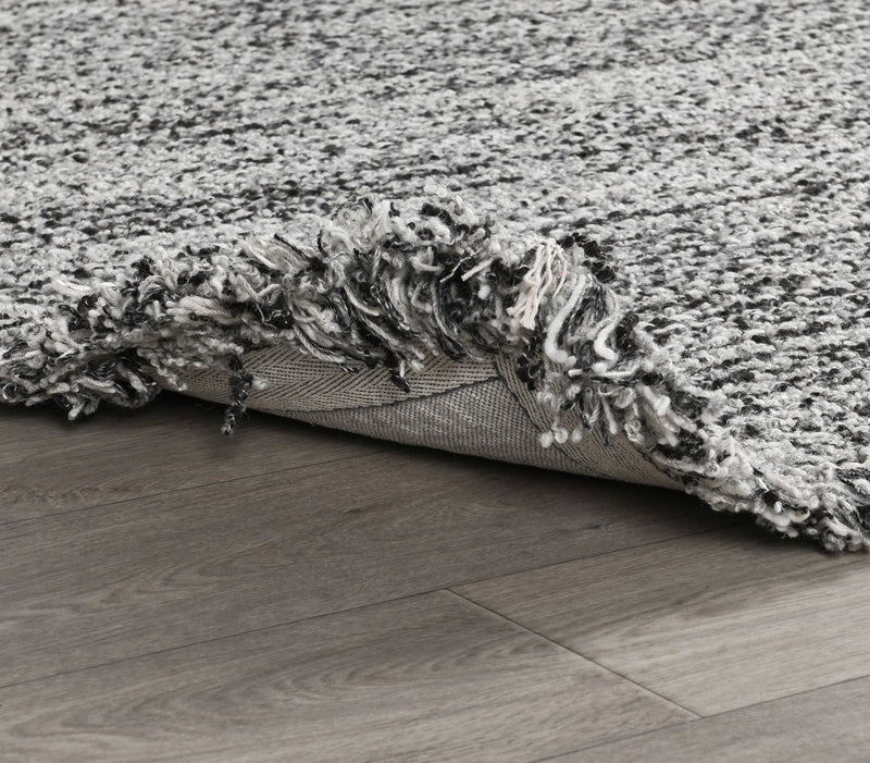 Wool rug with gray shag pile, flatweave backing, and low-profile edge