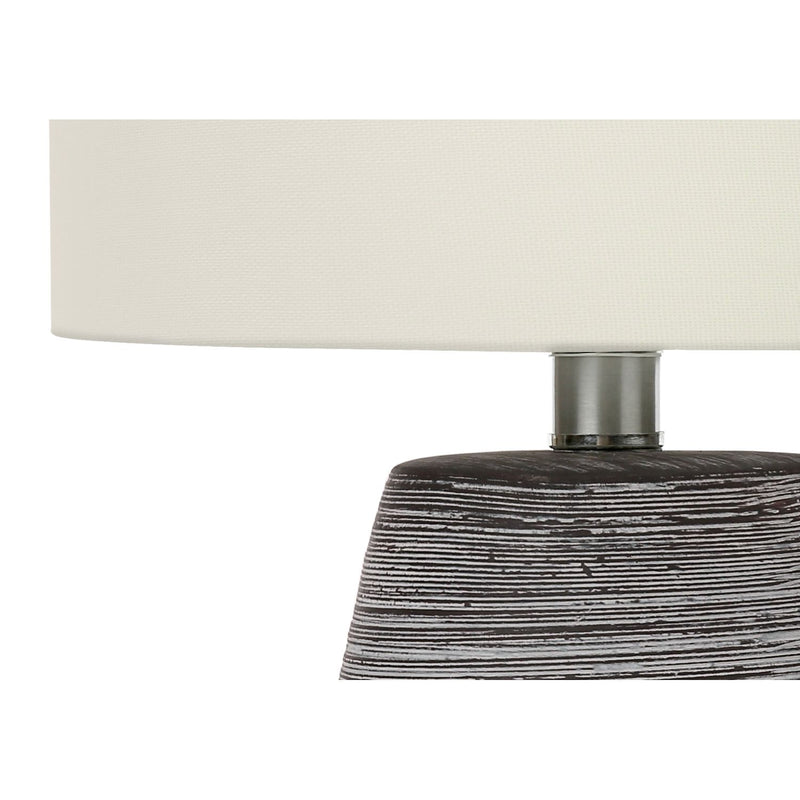 Gray ceramic lamp base with textured finish and silver neck under cream shade