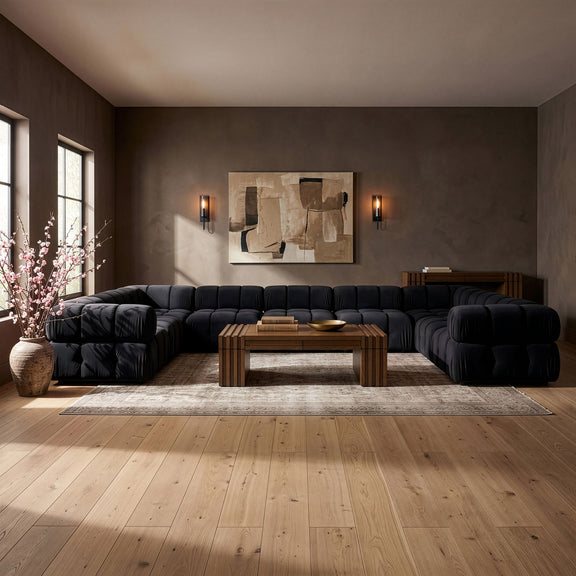 Black velvet sectional sofa with tufted cushions and rounded chaise sections