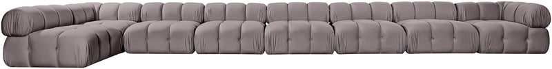 Gray velvet L-shaped sectional sofa with tufted cushions and rounded end arm.
