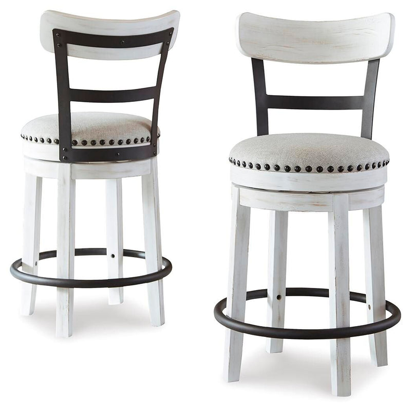 Pair of white swivel bar stools with studded round upholstered seats and black curved footrest rings