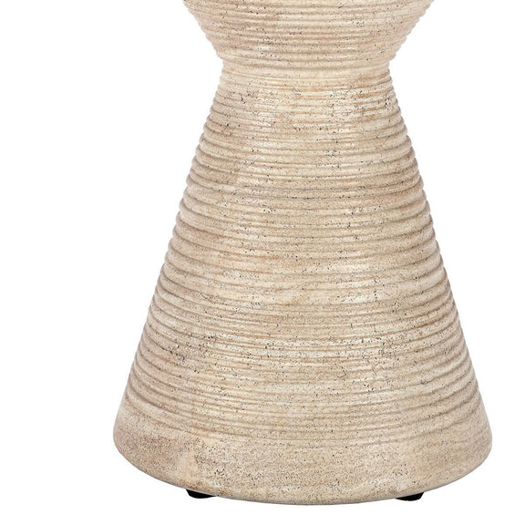 Beige outdoor accent table with hourglass base and textured speckled finish