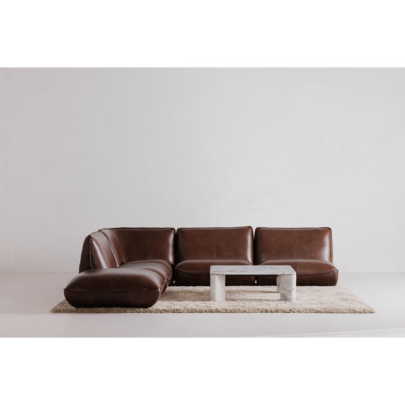 Gray marble-effect coffee table centered on rug in front of brown sofa
