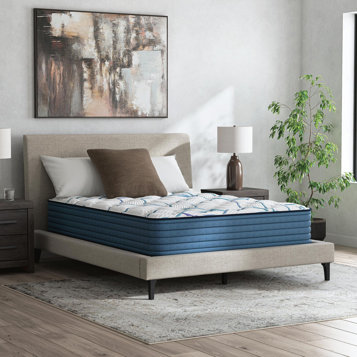 Plush mattress with white patterned cover on bed frame, bedroom display