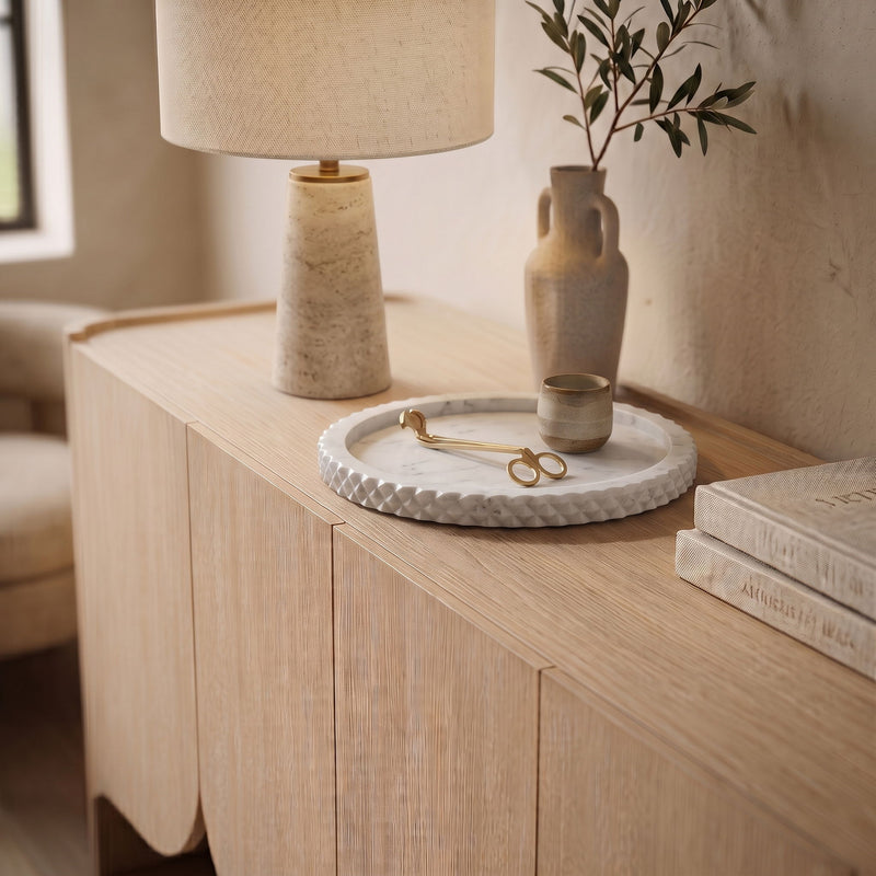 Round beige genuine marble tray with scalloped textured rim on tabletop