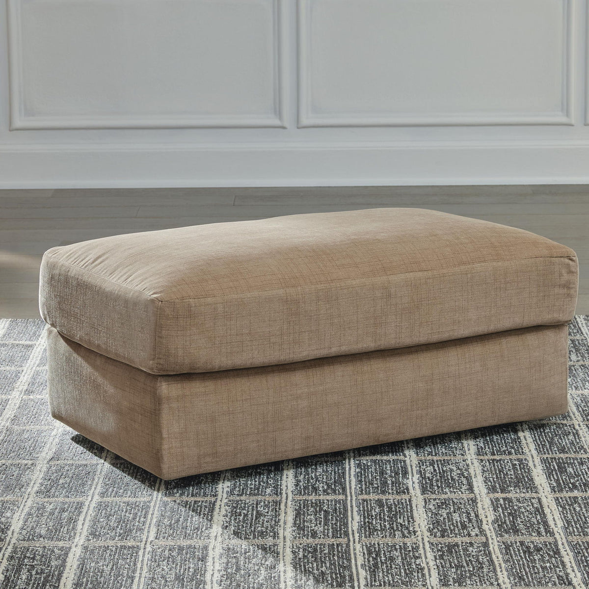 Honey beige fabric ottoman with padded top and visible short block legs