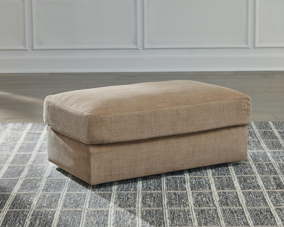 Honey beige fabric ottoman with padded top and visible short block legs