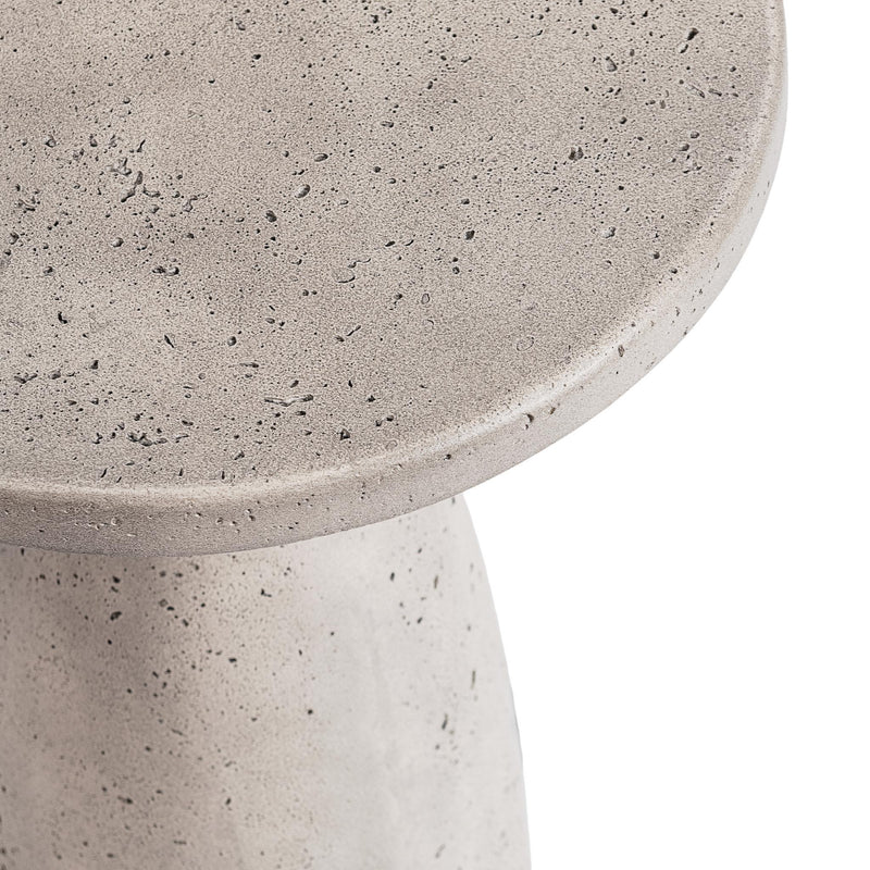 Outdoor accent table close-up: speckled light gray round tabletop and pedestal edge.