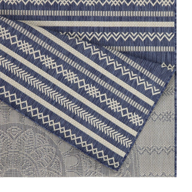 Indoor/outdoor area rug corner detail with blue stripes, zigzags, and light gray background