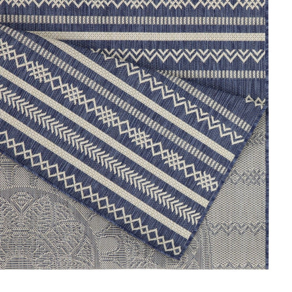 Indoor/outdoor area rug corner detail with blue stripes, zigzags, and patterned border bands