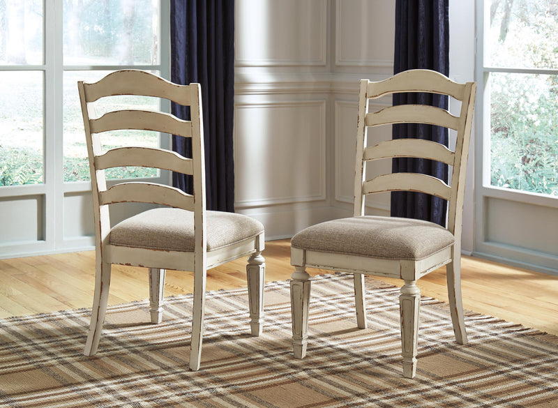 Pair of ladderback dining chairs with chipped white wood and taupe upholstered seat cushions.