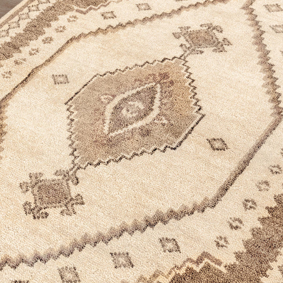Close-up of Luxor hand-knotted rug motif in cream and desert brown, diamond centerpiece