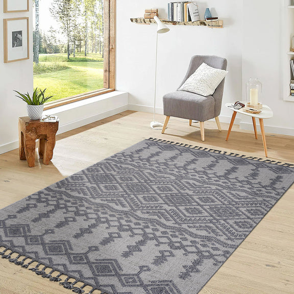 Gray and white geometric traditional area rug laid on floor with fringe edges