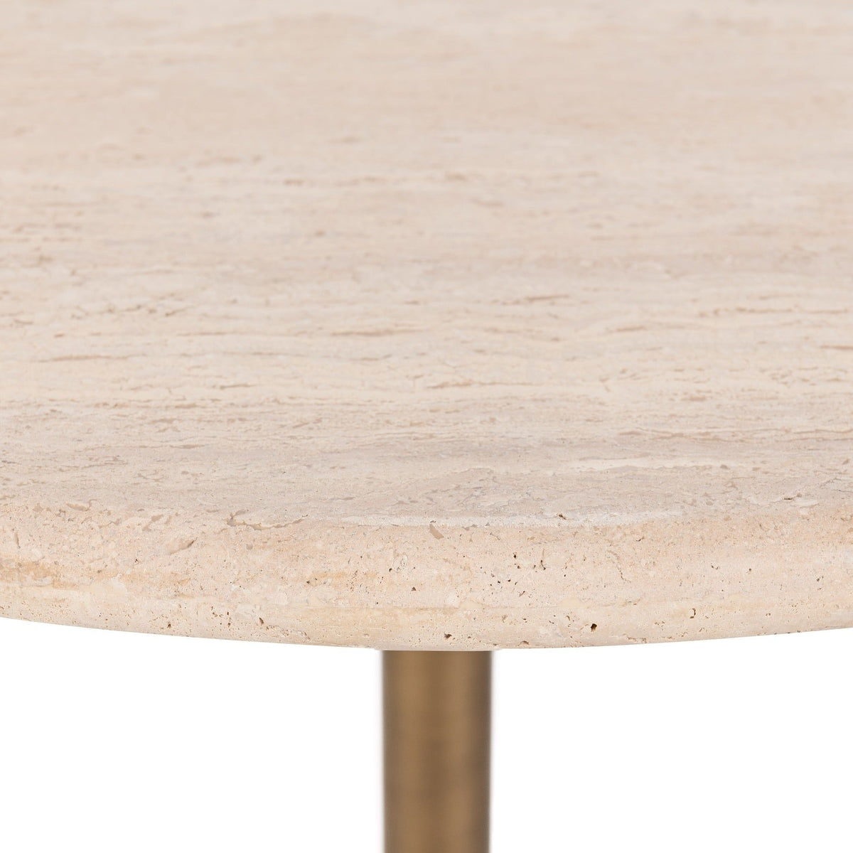 Close-up of travertine tabletop edge and textured beige surface.