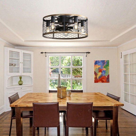 Black caged flush-mount ceiling fan with lit bulbs and wood-tone rim