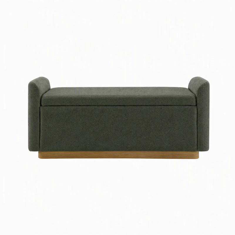 Dark green upholstered storage bench with cushioned lid and hinged safety support.