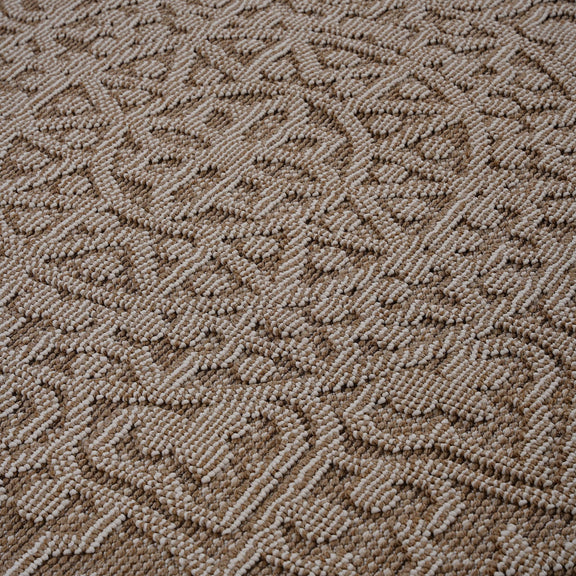 Close-up of beige medallion rug with raised textured diamond and swirl motif