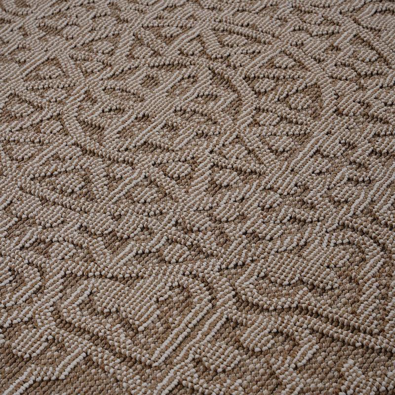 Close-up of beige medallion rug with raised textured diamond and swirl motif