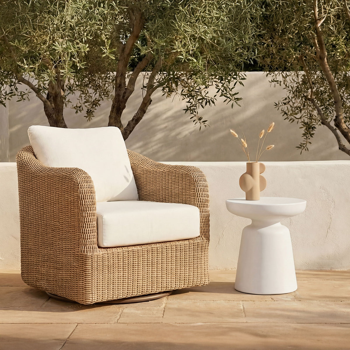 White pedestal side table with round top, shown outdoors