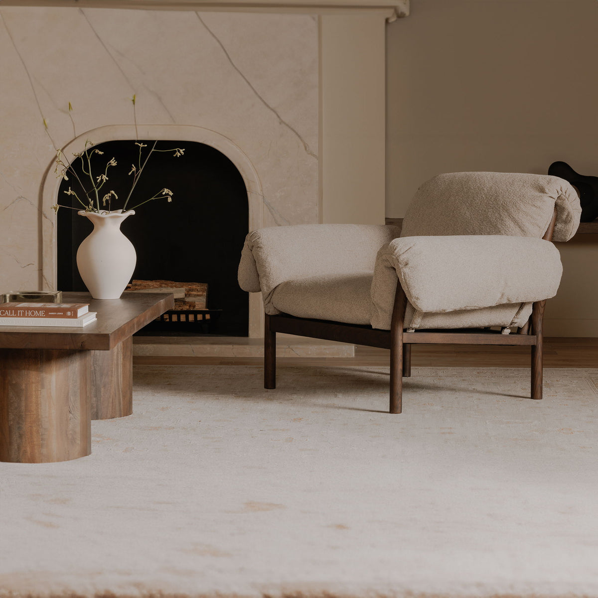 Beige lounge chair with cushioned arms and seat, dark wood frame and legs