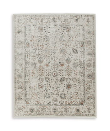Beige area rug with central floral design and subtle distressed detailing