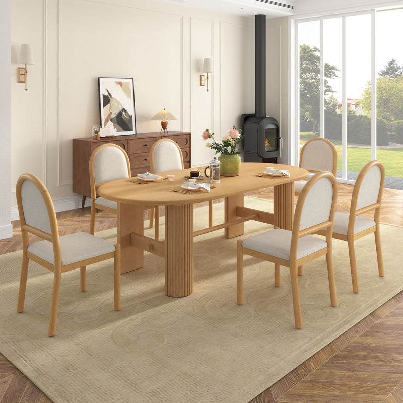 Light brown oval dining table with six upholstered chairs, fabric seats and rounded arched backs