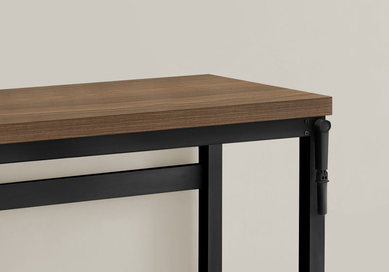 Standing adjustable computer desk with dark brown top and black frame, corner view