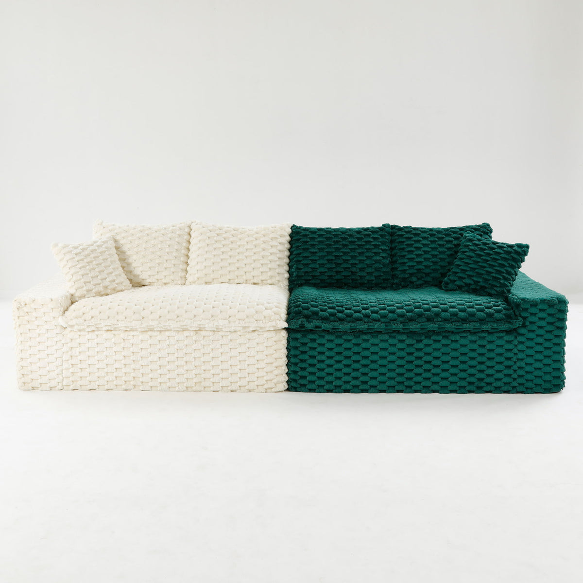 Two-tone chunky knit sofa with white base and dark green seat cushions and armrest