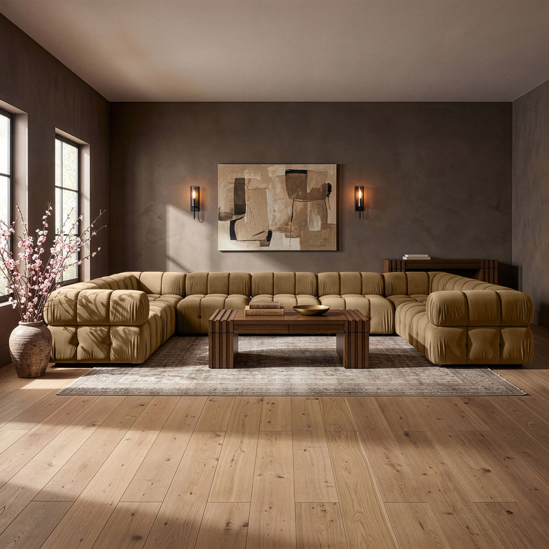 Light brown velvet sectional sofa with tufted cushions and rounded chaise corner ends
