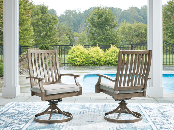 Two brown swivel patio chairs with gray cushions and slatted backrests on deck