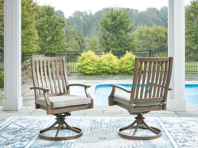 Two brown swivel patio chairs with gray cushions and slatted backrests on deck