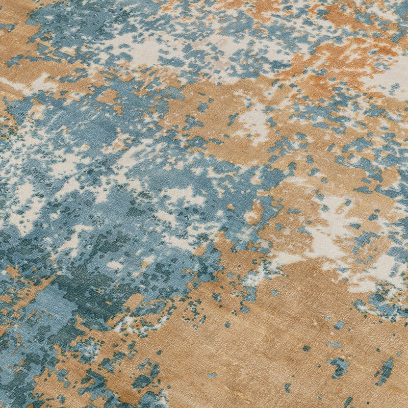 Blue, tan, and orange distressed abstract rug with speckled texture, close-up.