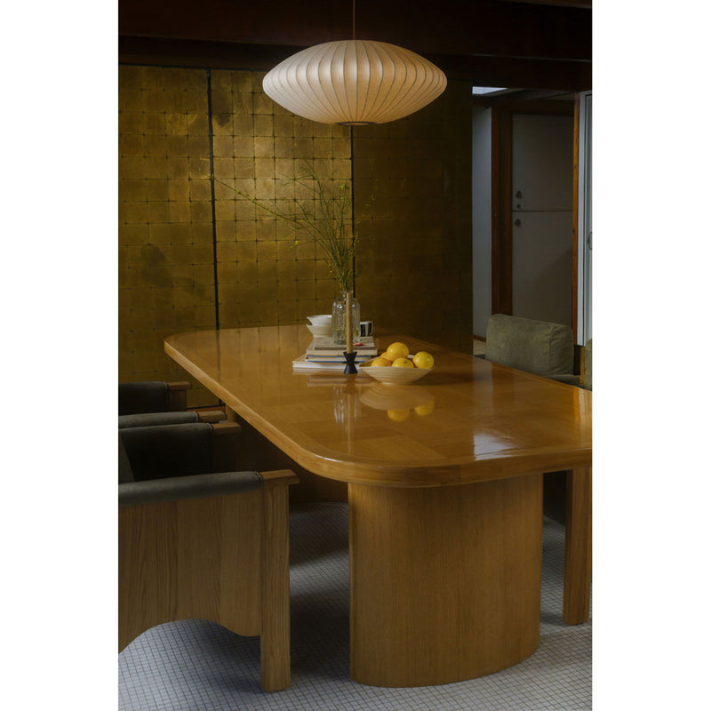 Light wood dining table with curved apron and sturdy base supports