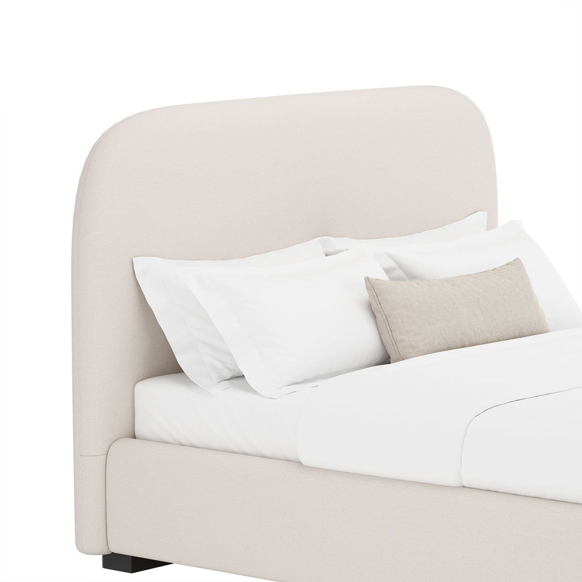 Beige upholstered bed detail with rounded headboard and white bedding with gray throw pillow