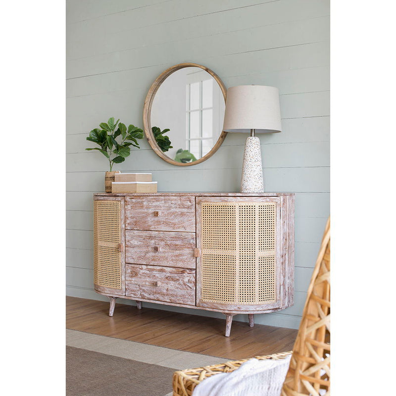 Cane-door TV console with three drawers, curved sides, and distressed pale wood finish