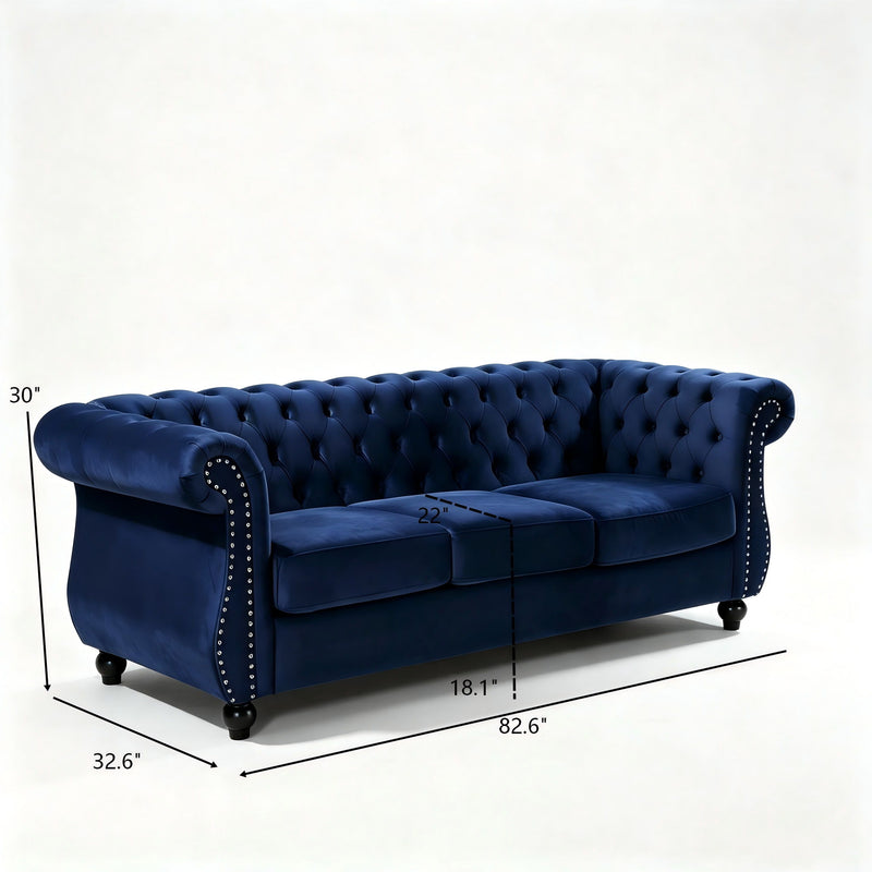 Blue three-seat button-tufted sofa, side view with rolled arms and stud trim
