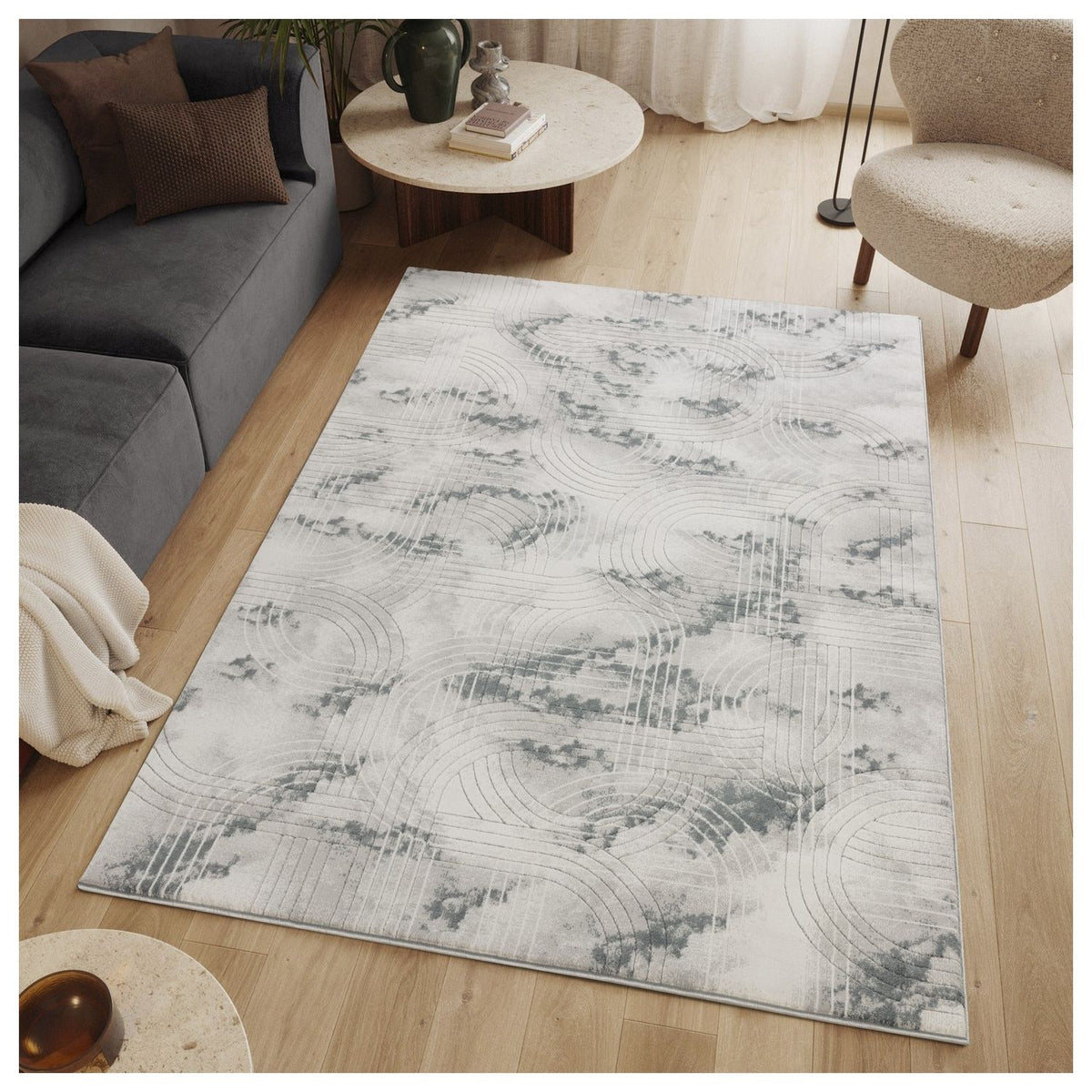 Gray area rug with geometric 3D swirling pattern in cloudlike bands.