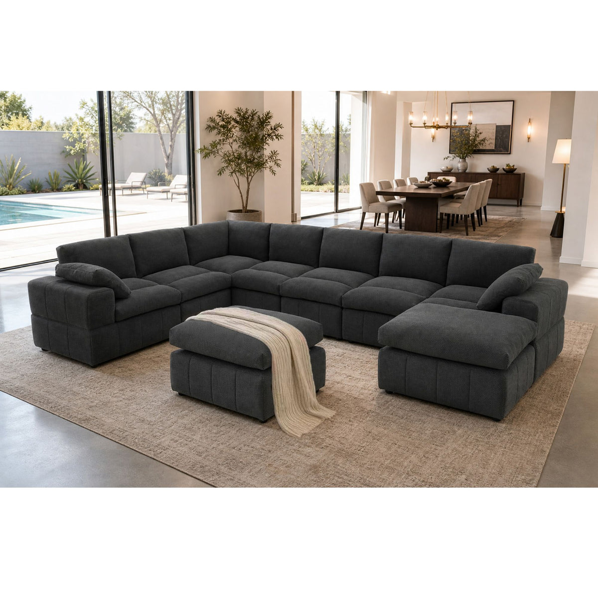 Dark gray U-shaped sectional sofa with wide arms and matching ottoman